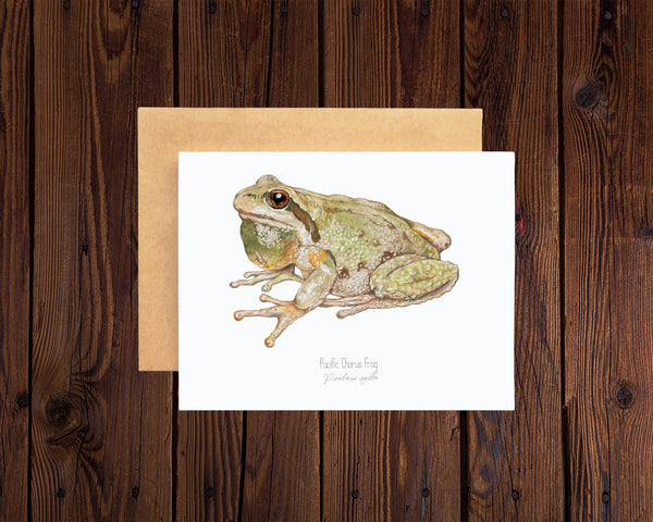 Greeting card with a frog illustration on a wooden surface